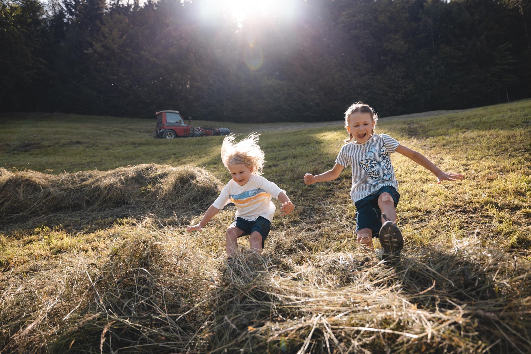 K1600 Kinder springen in Heuhaufen Spaß Familie Scheffachberg Reith Sommer Alpbachtal Tourismus Foto Mathäus Gartner 2 4